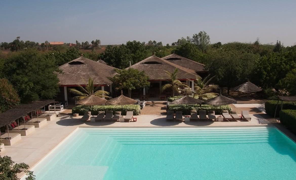 Piscine des Manguiers de Guéréo et bungalows à toit de paille en arrière-plan